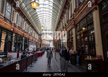 Stadtarbeiter genießen am 25. Mai 2023 einen Drink auf dem Leadenhall Market in der City of London in London, Großbritannien. Der Markt in der Gracechurch Street stammt aus dem 14. Jahrhundert. Es gibt Käsemonger, Metzger und Floristen. Ursprünglich war es ein Fleisch-, Wild- und Geflügelmarkt, der im Zentrum des römischen London stand. 1881 entworfen von Sir Horace Jones. Stockfoto