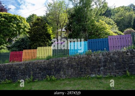 Am 7. Juni 2023 in der Hebden Bridge, Großbritannien, wurde ein heller Zaun in Regenbogenfarben um ein Haus gelegt. Die Hebden Bridge ist eine Marktstadt im Upper Calder Valley in West Yorkshire. In den 1970er und 1980er Jahren kam es in der Stadt zu einem Zustrom von Künstlern, Kreativen und alternativen Praktizierenden sowie Grün- und Neuzeitaktivisten. In jüngerer Zeit erlebten wohlhabendere Fachleute, die seinerseits einen Boom des Tourismus in die Gegend verzeichneten, der noch verschlimmert wurde, nachdem die populäre Verbrechensserie Happy Valley gedreht und in und um die Stadt gedreht wurde. Stockfoto