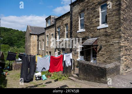 Kleidung, die am 7. Juni 2023 an einer Wäscheleine vor einem Haus hängt, das ein üblicher Anblick außerhalb von Häusern im Norden ist, in der Hebden Bridge, Großbritannien. Die Hebden Bridge ist eine Marktstadt im Upper Calder Valley in West Yorkshire. In den 1970er und 1980er Jahren kam es in der Stadt zu einem Zustrom von Künstlern, Kreativen und alternativen Praktizierenden sowie Grün- und Neuzeitaktivisten. In jüngerer Zeit erlebten wohlhabendere Fachleute, die seinerseits einen Boom des Tourismus in die Gegend verzeichneten, der noch verschlimmert wurde, nachdem die populäre Verbrechensserie Happy Valley gedreht und in und um die Stadt gedreht wurde. Stockfoto