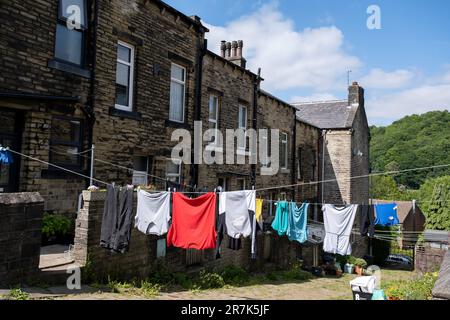 Kleidung, die am 7. Juni 2023 an einer Wäscheleine vor einem Haus hängt, das ein üblicher Anblick außerhalb von Häusern im Norden ist, in der Hebden Bridge, Großbritannien. Die Hebden Bridge ist eine Marktstadt im Upper Calder Valley in West Yorkshire. In den 1970er und 1980er Jahren kam es in der Stadt zu einem Zustrom von Künstlern, Kreativen und alternativen Praktizierenden sowie Grün- und Neuzeitaktivisten. In jüngerer Zeit erlebten wohlhabendere Fachleute, die seinerseits einen Boom des Tourismus in die Gegend verzeichneten, der noch verschlimmert wurde, nachdem die populäre Verbrechensserie Happy Valley gedreht und in und um die Stadt gedreht wurde. Stockfoto