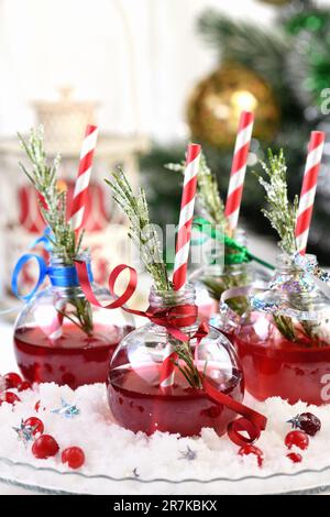 Gin mit Tonic und Preiselbeersaft. Der Cocktail ist voller festlicher Weihnachtsaromen. Serviert in transparenten Schüsseln mit einem Zweig Rosmarin. Stockfoto