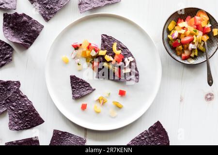 Blaue Corn Tortilla Chips gekrönt mit hausgemachter Salsa Stockfoto