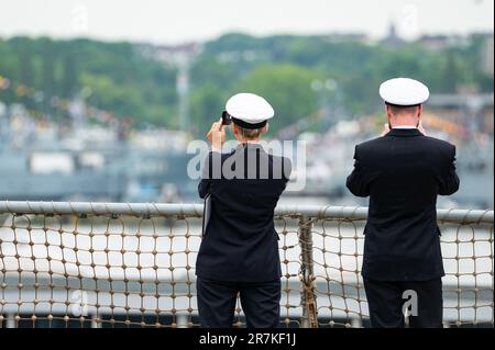 Kiel, Deutschland. 16. Juni 2023. Zwei Offiziere stehen auf dem Deck eines Schiffes und fotografieren den Marinestützpunkt Kiel-Wik. Das traditionelle Manöver „Baltops“ in der Ostsee endet am Freitagmorgen in Kiel. Der Schwerpunkt der Übung, die im Juni 4 begann, war die Sicherung offener Seerouten in der Ostsee, so die Marine. Kredit: Jonas Walzberg/dpa/Alamy Live News Stockfoto