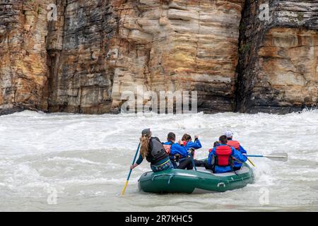 Nahaufnahme von Menschen in Wildwasser-Floß auf dem Athabasca River, der von nahe gelegenen Athabasca Falls, Jasper National Park, ab, Kanada, fließt, mit bunten Liegen Stockfoto