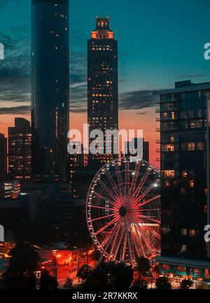 Ein Luftblick auf Atlanta City mit einer Reihe hoher Wolkenkratzer und einem großen Riesenrad im Vordergrund Stockfoto