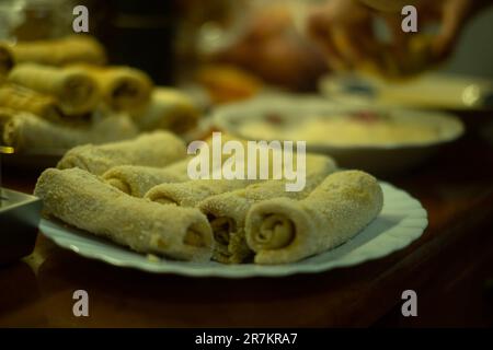 Auf einem Tisch wird eine Auswahl an frisch zubereiteten Speisen ausgestellt, darunter eine Auswahl an Brötchen und anderen Gerichten Stockfoto