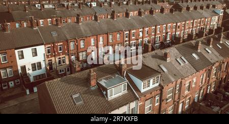 Ein Blick aus der Vogelperspektive über die Dächer heruntergekommener, hintereinander angeordneter Terrassenhäuser auf einem Arbeiterwohnungsgut im Norden Englands Stockfoto