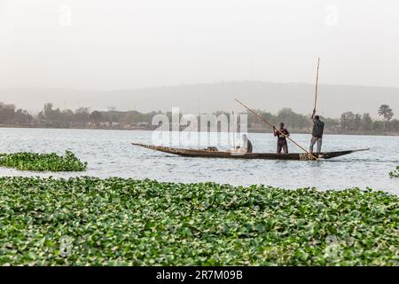 Drei Fischer auf ihrem Pirogue, die den Niger in Bamako entlang zu ihrem Angelplatz fahren. Stockfoto