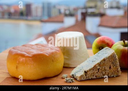 Asturische Käsesorten, hart geräucherter Kuhkäse von Pria, Blaukäse-Cabralis von Arenas und weißer Rebollin aus Pitu, Asturien, serviert im Freien mit Aussicht Stockfoto