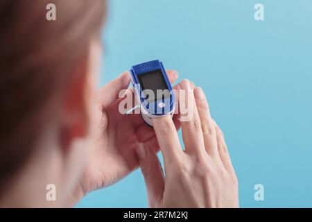 Frauen-Selbsttest auf Blutsauerstoffspiegel mit dem Pulsoxymeter Stockfoto