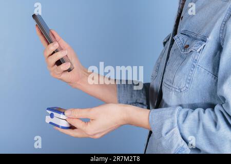Frauen-Selbsttest auf Blutsauerstoffspiegel mit dem Pulsoxymeter Stockfoto