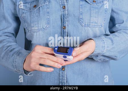Frauen-Selbsttest auf Blutsauerstoffspiegel mit dem Pulsoxymeter Stockfoto