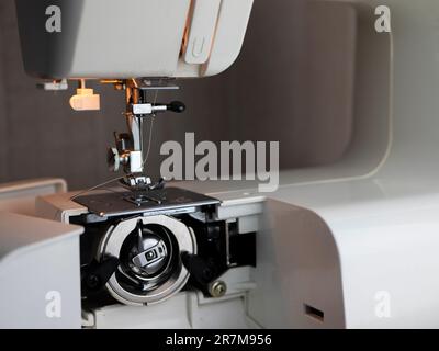 Das Spulenkoffer ist in der Maschine für die Verwendung von Spulen mit Frontlader, Nahaufnahmen und selektive Fokussierung vorgesehen. Konzept der Gewindeschneidung der Nähmaschine Stockfoto
