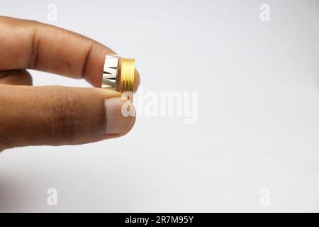 Silber- und Goldring in neuem Zustand in der Hand gehalten auf weißem Hintergrund Stockfoto