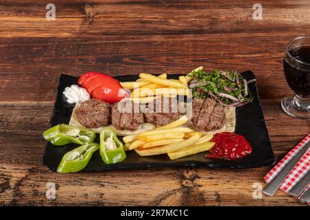 Türkisches Fleischklößchen, traditionelles Kofte. Scharfe Fleischbällchen Kebab oder Kebap. Türkische Fleischbällchen mit frischen grünen Paprika und Gurken. Stockfoto