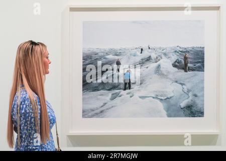 London, den 16. Juni 2023. Ein Besucher schaut sich den Landschaftsfotografen Olaf Otto Becker „Point 660, 2, 08/2008“ aus seiner Serie „Above Zero“ an und stellt Touristen vor, die Fotos von einer eisigen Gletscherlandschaft machen. Zivilisation: The Way We Live Now ist eine Wahrzeichen-Ausstellung, die die visuellen Fäden des sich ständig ändernden, außergewöhnlich komplexen Lebens der Menschheit auf der ganzen Welt durch die Augen von 150 der weltweit erfolgreichsten Fotografen verfolgt. Zivilisation: The Way We Live Now ist bis zum 17. September in der Saatchi-Galerie. Kredit: Imageplotter/Alamy Live News Stockfoto