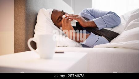 Junger Mann angesteckt mit Wechselbäder seine Nase in Taschentuch Stockfoto