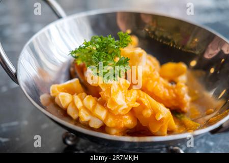 Gebratener Tintenfisch mit Currypulver, serviert auf dem Teller Stockfoto