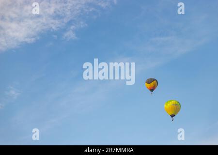 Ein Bild von zwei farbenfrohen Heißluftballons, die auf einem blauen Himmel in Kappadokien fliegen. Stockfoto