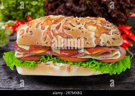 Sandwich mit Tomaten, Mozzarella, Salat, Salami Stockfoto