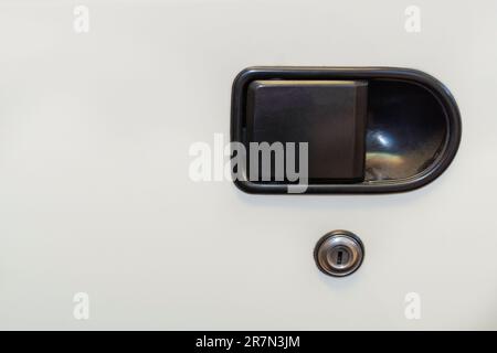 Türgriff und Schloss des alten Autos. Weißes Auto. Schwarzer Griff. Selektiver Fokus. Stockfoto