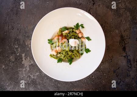 Top View Pasta mit Lachs und rotem Kaviar und Grün auf einem weißen Teller Stockfoto