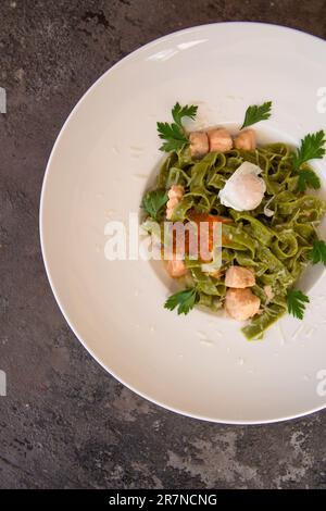 Top View Pasta mit Lachs und rotem Kaviar und Grün auf einem weißen Teller Stockfoto