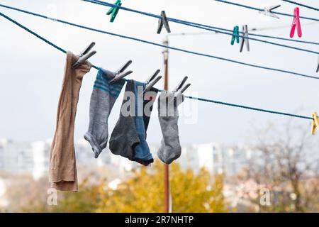 An der Wäscheleine hängt ein Wäschekorb. Ein Seil mit sauberer Bettwäsche und Kleidung draußen am Tag der Wäsche. Vor dem Hintergrund der grünen Natur Stockfoto