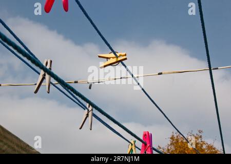 An der Wäscheleine hängt ein Wäschekorb. Ein Seil mit sauberer Bettwäsche und Kleidung draußen am Tag der Wäsche. Vor dem Hintergrund der grünen Natur Stockfoto