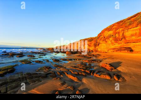 Ebbe am felsigen Sandstrand in Caves Beach an der Pazifikküste australiens - Sonnenaufgang am Meer. Stockfoto