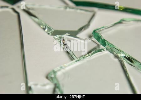Gebrochene Glasstapelstücke mit Struktur und Hintergrund, isoliert auf weißem, rissigem Fenstereffekt. Notfallzustand Stockfoto