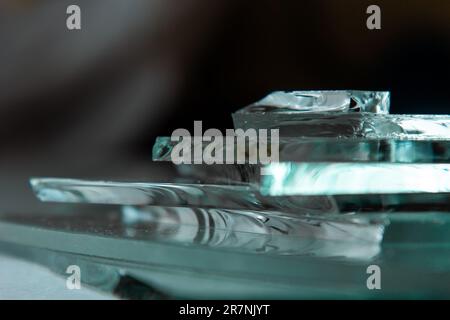 Zerbrochener Glashintergrund für Ihre Bilder, isoliert auf Weiß. Viele große Glassplitter, die aus einem Hammer als Begriff der Gewalt zerstreut werden Stockfoto