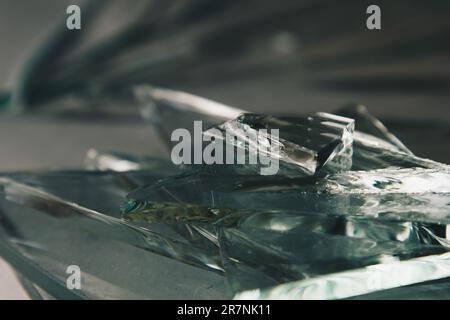 Zerbrochener Glashintergrund für Ihre Bilder, isoliert auf Weiß. Viele große Glassplitter, die aus einem Hammer als Begriff der Gewalt zerstreut werden Stockfoto