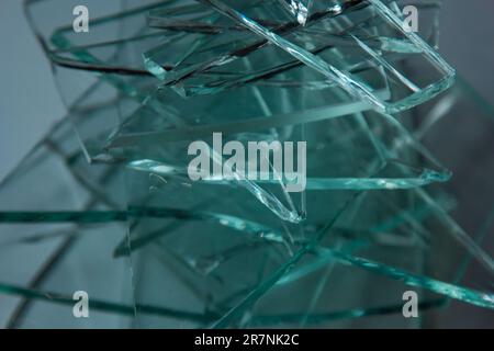 Zerbrochener Glashintergrund für Ihre Bilder, isoliert auf Weiß. Viele große Glassplitter, die aus einem Hammer als Begriff der Gewalt zerstreut werden Stockfoto