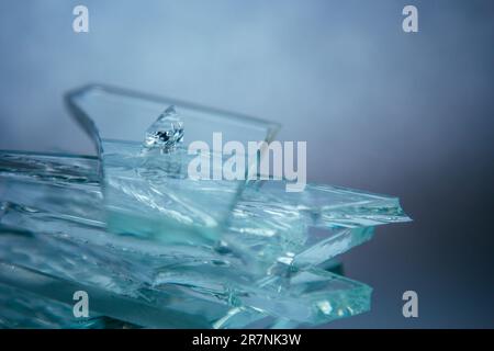 Zerbrochener Glashintergrund für Ihre Bilder, isoliert auf Weiß. Viele große Glassplitter, die aus einem Hammer als Begriff der Gewalt zerstreut werden Stockfoto