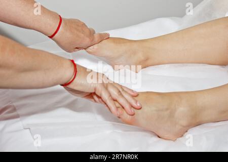 Professionelle therapeutische Fußmassage. Frau Doktor Massagen der Athlet in einen Massageraum. Körper und Gesundheit. Schmerzen. Stockfoto