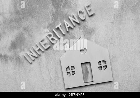 Worterbe mit weißen Buchstaben und Modellhaus auf grauem Hintergrund, flach liegend Stockfoto