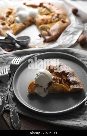 Köstliche Apfelgalette mit Eiscreme auf einem Holztisch Stockfoto