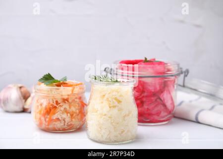 Köstliches Sauerkraut, nach verschiedenen Rezepten auf einem weißen Tisch zubereitet Stockfoto
