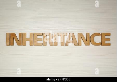 Wortvererbung mit Buchstaben auf Holzhintergrund, flach liegend Stockfoto