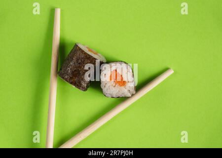 Sushi mit Lachs auf grünem Hintergrund aus nächster Nähe, Restaurantessen Stockfoto