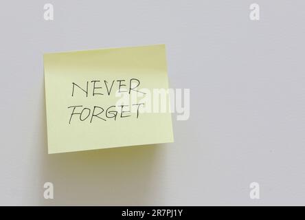 Gelbe Haftnotiz an weißer Wand mit einer Erinnerung an das Gedächtniskonzept Stockfoto