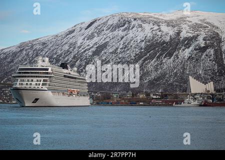 Ein majestätisches Kreuzfahrtschiff der VikingerVenus legte im Hafen von Tromso vor schneebedeckten Bergen an Stockfoto