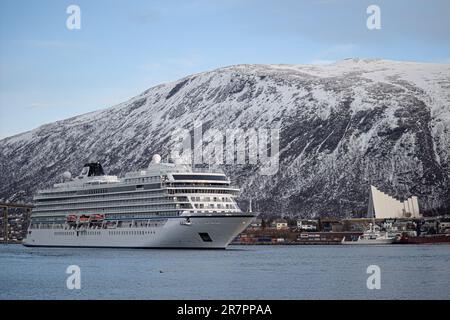 Ein majestätisches Kreuzfahrtschiff der VikingerVenus legte im Hafen von Tromso vor schneebedeckten Bergen an Stockfoto