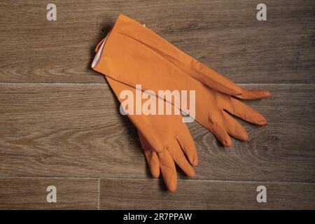 Orangefarbene Gummihandschuhe liegen Nahaufnahme auf dem Tisch Stockfoto