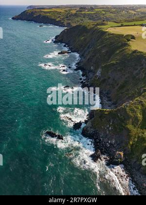 Luftaufnahme der zerklüfteten Küste von Cornwall in der Nähe des Dorfes Kuggar mit dem klaren Ozean auf den Felsen. Stockfoto