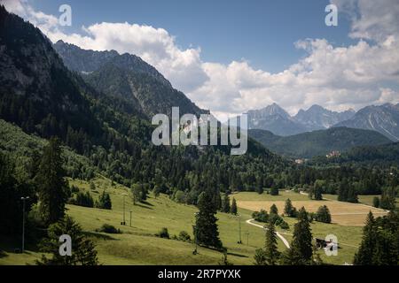 Schwangau, Deutschland. 15. Juni 2023. Schloss Neuschwanstein (M) in der Nähe von Füssen in Allgäu, eine der berühmtesten Sehenswürdigkeiten in Bayern und Deutschland, deren Bau 1869 in der Berglandschaft der Alpen begann. Ganz rechts, das ältere Schloss Hohenschwangau. Kredit: Frank Rumpenhorst/dpa/Alamy Live News Stockfoto