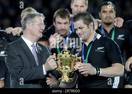 Neuseelands Hauptmann Richie McCaw erhält den Pokal vom IRB-Vorsitzenden Bernard Lapasset, nachdem er Frankreich im Finale der Rugby-Weltmeisterschaft am Sonntag, den 23. Oktober, in Eden Park, Auckland, Neuseeland, besiegt hatte. 2011. Stockfoto