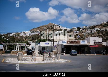 IOS, Griechenland - 21. Mai 2021 : Blick auf einen Kreisverkehr, Geschäfte und das malerische Dorf iOS Greece im Hintergrund Stockfoto