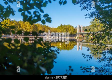 Von der Vegetation umrahmter Blick auf die Hängebrücke von Cajarc, entlang des Camino de Santiago Trail, an einem sonnigen Herbsttag ohne Menschen Stockfoto